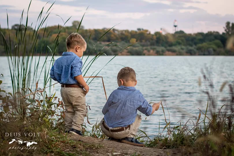 Two children fishing beside a lake, photographed by Deus Volt Photography