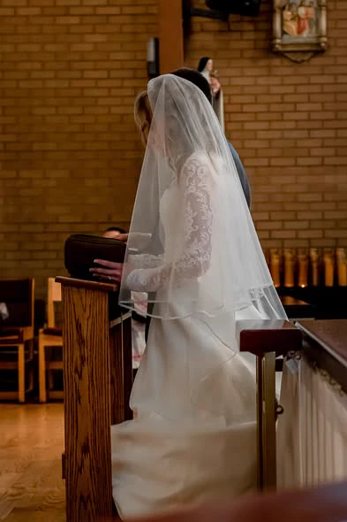 Bride in a lace veil standing in a church